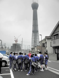 スカイツリーを目の前に説明を聞く生徒たち