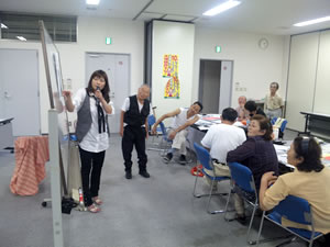 出来上がったしんぶんを前に説明をする綾瀬・坂田編集長