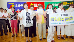 出陣式で合唱をリードする女性の会